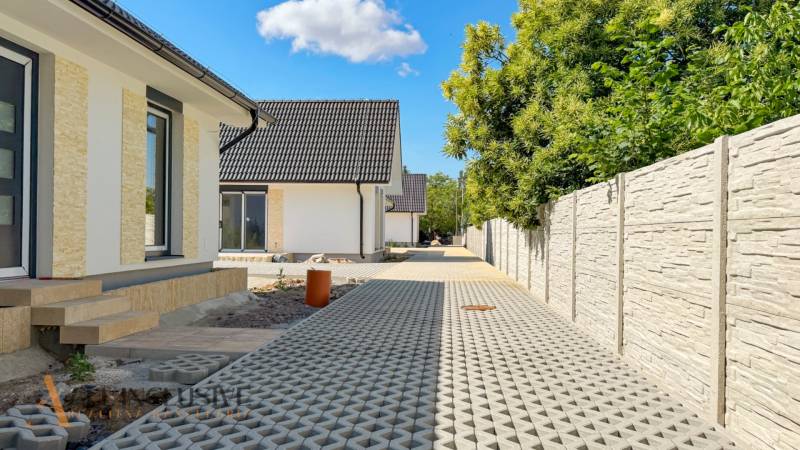 NOVINKA!!! MODERNÉ NOVOSTAVBY NA KĽÚČ | ZLATÉ MORAVCE  - Rodinný dom na Vajanského ulici v Zlatých Moravciach s dlažbou a drevinami.