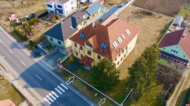  POLYFUNKČNÝ OBJEKT | CHRABRANY | TOPOĽČANY - Budova na ulici Chrabrany v Topoľčanoch, obklopená domami a zeleňou.