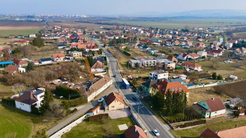  POLYFUNKČNÝ OBJEKT | CHRABRANY | TOPOĽČANY - Pohľad na domy a ulice v Chrabranoch, Topoľčany, pod jasnou oblohou.