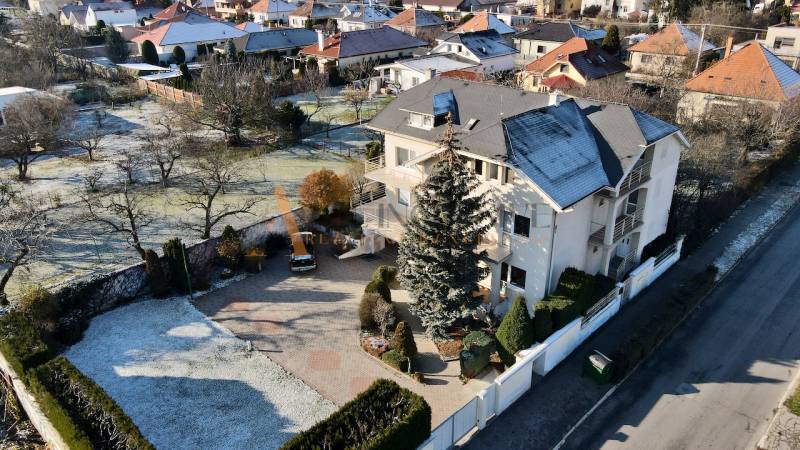 UBYTOVANIE PRE FIRMY - APARTMÁNY | TOPOĽČANY - Vila na ulici Športovcov v Topoľčanoch, obklopená zeleňou a bielym plotom.