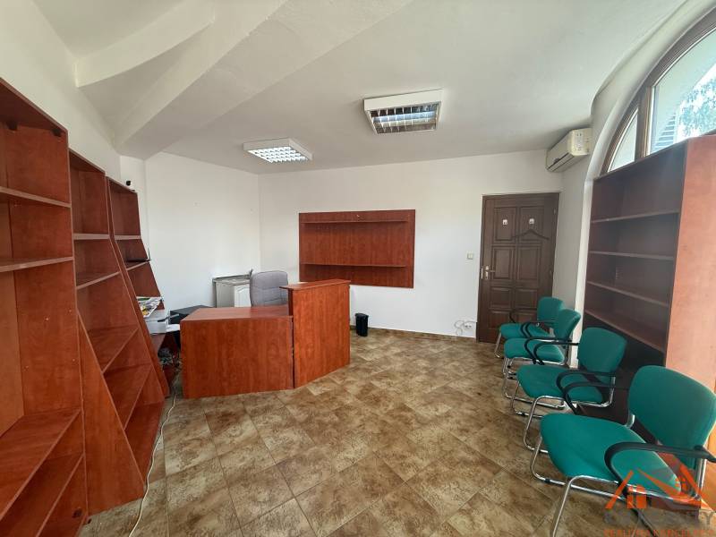 VÝBORNÁ LOKALITA! Na prenájom obchodný - kancelársky priestor Komárno - Kancelárie s dreveným nábytkom a zelenými stoličkami, dlažba, okno s oblúkom.