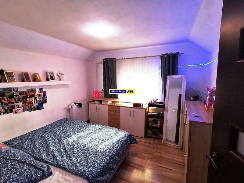 Rodinný dom na predaj Sučany, úplne prerobený ako novostavba - Spálňa v rodinnom dome s drevenou podlahou, dekoráciami a úložným priestorom.
