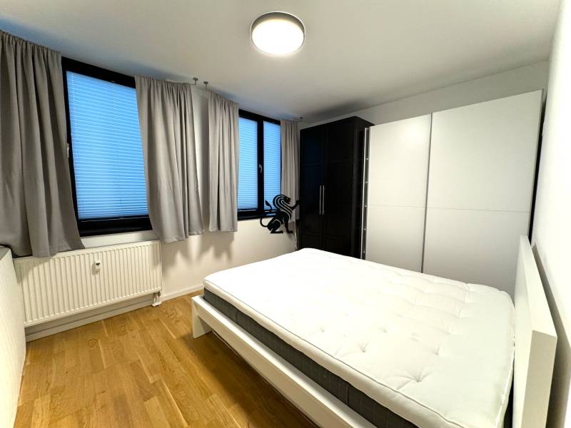 Budova s 8 apartmánmi alebo medicínske centrum, 9 park. miest- Kolibe - Spálňa so sivými závesmi, bielou skriňou a drevenou podlahou, na ulici Na varte.
