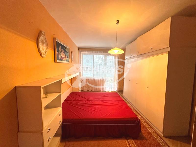 PRENÁJOM - 3 izbový byt s balkónom, Šafárikova ulica, Rožňava - Spálňa so vstavanými skriňami, posteľou s červenou prikrývkou v 3-izbovom byte.