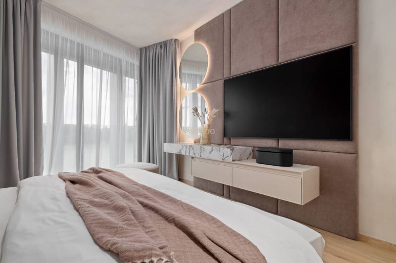 - PRENÁJOM - 3,5 IZBOVÝ BYT - EUROVEA II - LUXUSNÝ - Spálňa v 3-izbovom byte so zrkadlom, TV a závesmi.