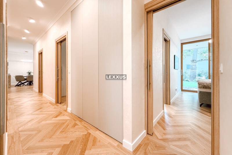 PREDAJ | Jedinečná rezidencia so záhradou v Hausbergu, Staré mesto - Chodba v 4-izbovom byte s drevenou podlahou a pohľadom do izby.