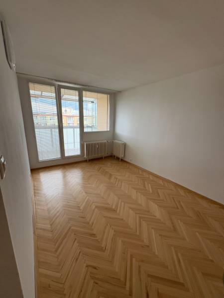 2-izbový byt s 1 veľkým balkónom a 1 menším balkónom v Novej Dubnici. - Izba v 2-izbovom byte s parketovou podlahou a veľkým oknom s výhľadom.