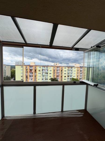 2-izbový byt s 1 veľkým balkónom a 1 menším balkónom v Novej Dubnici. - Zasklený balkón s výhľadom na farebné bytovky v Novej Dubnici na ulici SNP.