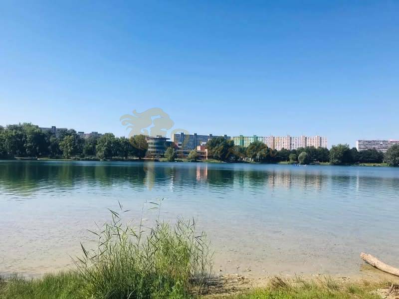 1-izb. apartmán, Antolska ul., Petržalka, rezidencia Draždiak - Pohľad na jazero s budovami v Bratislave - Petržalka, Antolská, v pozadí.