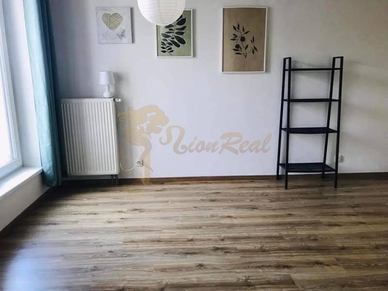 1-izb. apartmán, Antolska ul., Petržalka, rezidencia Draždiak - Prázdna miestnosť s drevenou podlahou, policovým regálom a tromi obrazmi na stene.