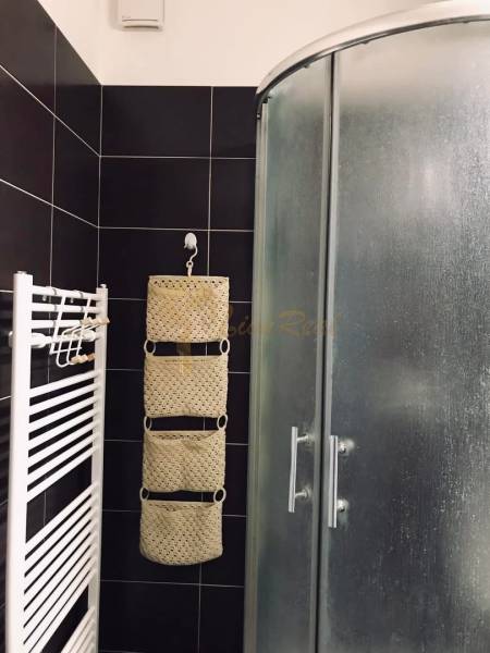 1-izb. apartmán, Antolska ul., Petržalka, rezidencia Draždiak - Kúpeľňa s čiernymi dlaždicami, sprchovým kútom a radiátorom v 1-izbovom byte.