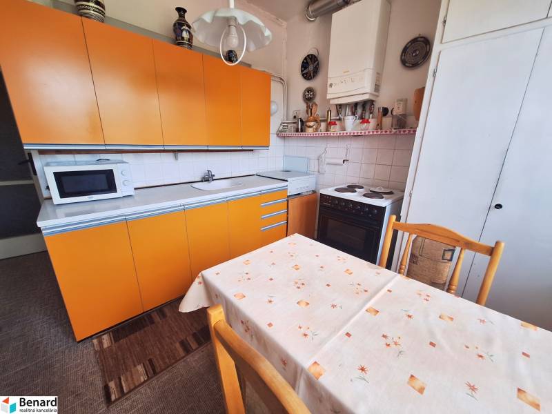 REZERVOVANÝ 2 IZBOVÝ TEHLOVÝ BYT, BALKÓN, ŠIRŠIE CENTRUM, PREŠOV - Kuchyňa 2-izbového bytu so žltými skrinkami a jedálenským stolom.