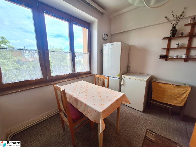 REZERVOVANÝ 2 IZBOVÝ TEHLOVÝ BYT, BALKÓN, ŠIRŠIE CENTRUM, PREŠOV - Jedáleň 2-izbového bytu so stolom, chladničkou a vitrínou na stene.