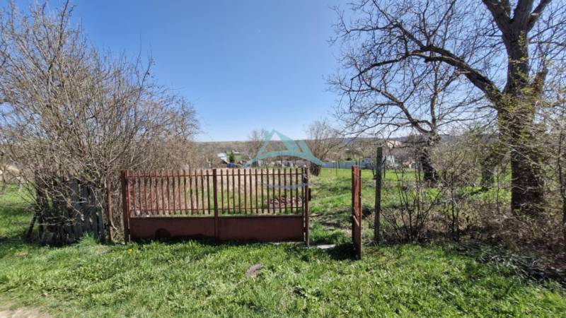 Pozemok (2394 m2) v Obeckove, okres Veľký Krtíš. - Voľné pozemky na bývanie s bránkou, obklopené jarnou prírodou a výhľadom na krajinu.