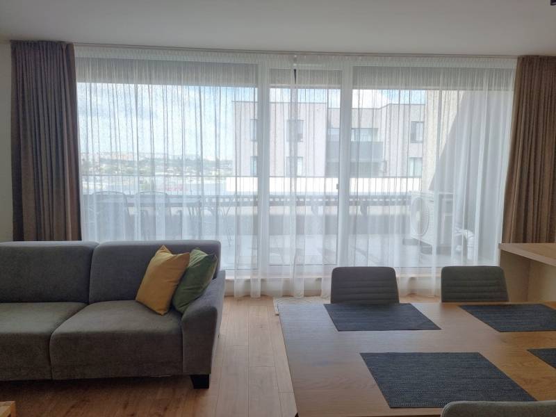 PRENÁJOM - 3 izbový byt Nitra – Piesková ulica, RIVIERA NITRA - Obývačka 3-izbového bytu s pohovkou, jedálenským stolom a výhľadom na balkón.