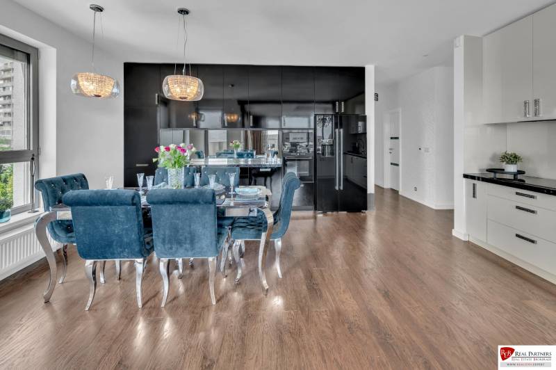 Predaj, Luxusný 4 izbový byt, 180 m2 + 25 m2, Condominium Renaissance - Kuchyňa v 4-izbovom byte s tmavými skrinkami, jedálenským stolom a drevenou podlahou.