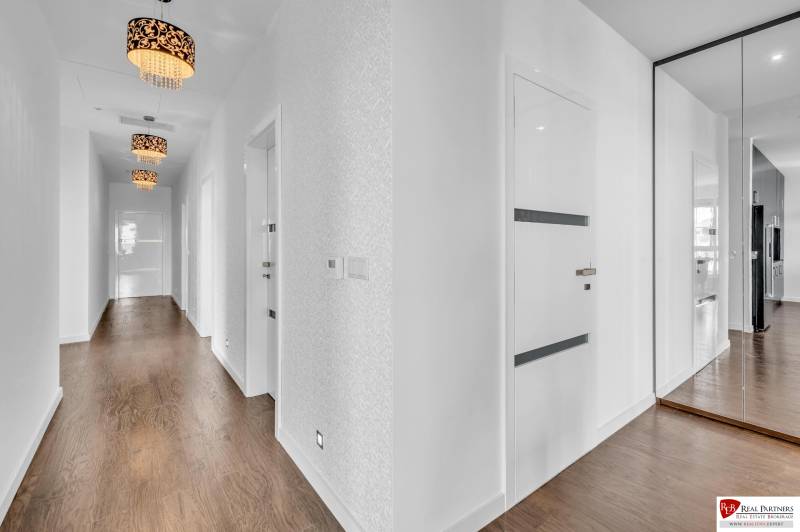 Predaj, Luxusný 4 izbový byt, 180 m2 + 25 m2, Condominium Renaissance - Chodba 4-izbového bytu so zrkadlovou skriňou a drevenou podlahou.