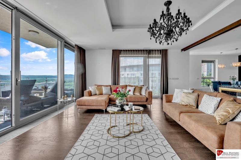 Predaj, Luxusný 4 izbový byt, 180 m2 + 25 m2, Condominium Renaissance - Štýlová obývačka v 4-izbovom byte so sedačkou, lustrom a výhľadom na terasu.