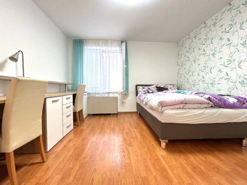 PREDAJ-GARSÓNKA-20m2-GUOTHOVA- KRAMÁRE - Spálňa v garsónke s pracovným stolom, lôžkom a dekoračnou tapetou.