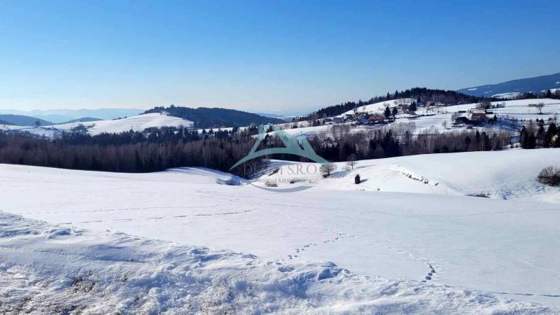 Pozemok (7750m2) s výhľadom na Nízke Tatry. - Zasnežená krajina s kopcami a lesmi, ideálna lokalita pre bývanie. Pozemky krásne viditeľné.
