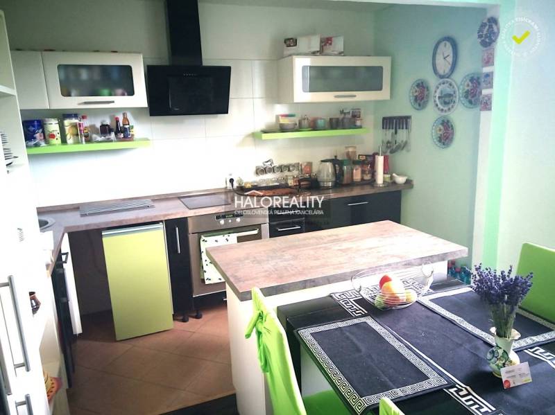 Predaj, rodinný dom Nováky - EXKLUZÍVNE HALO REALITY - Kuchyňa v rodinnom dome so zelenými a bielymi skriňami a jedálenským stolom.