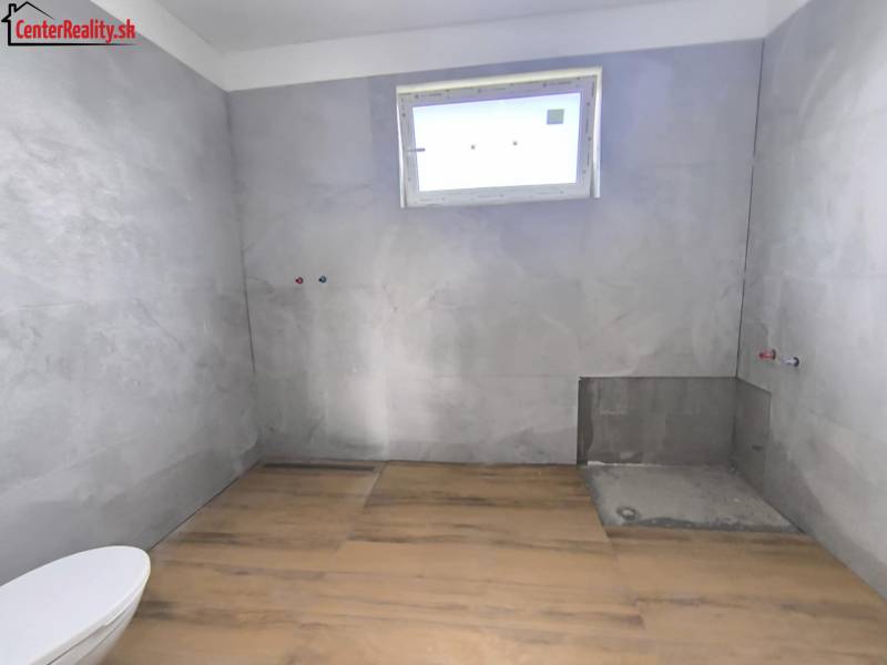 ‼️ NOVO POSTAVENÝ RODINNÝ DOM  S GARÁŽOU NA PREDAJ, MALÉ KRŠTEŇANY  ‼️ - Kúpeľňa v rodinnom dome s dlažbou, pripravená na inštaláciu, svetlo cez malé okno.