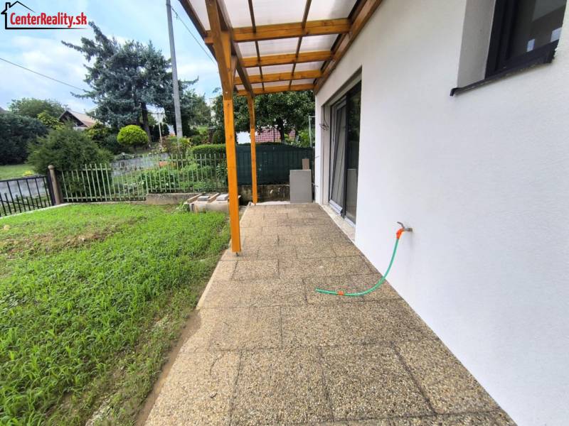 ‼️ NOVO POSTAVENÝ RODINNÝ DOM  S GARÁŽOU NA PREDAJ, MALÉ KRŠTEŇANY  ‼️ - Terasa rodinného domu v Malých Kršteňanoch s výhľadom na záhradu a plot.