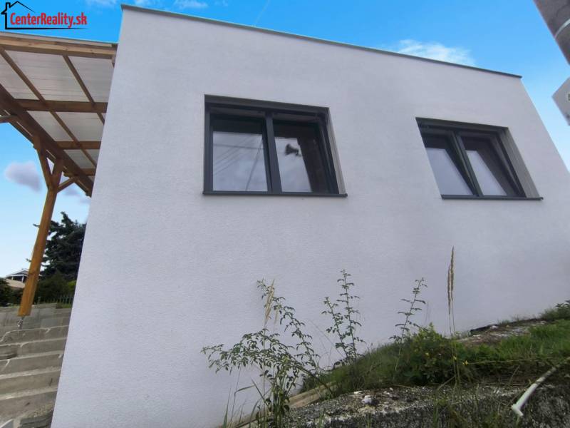 ‼️ NOVO POSTAVENÝ RODINNÝ DOM  S GARÁŽOU NA PREDAJ, MALÉ KRŠTEŇANY  ‼️ - Rodinný dom v Malých Kršteňanoch s dvojicou veľkých okien a dreveným prístreškom.