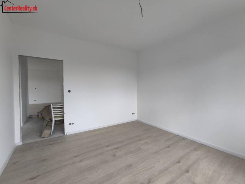 ‼️ NOVO POSTAVENÝ RODINNÝ DOM  S GARÁŽOU NA PREDAJ, MALÉ KRŠTEŇANY  ‼️ - Prázdna izba s bielymi stenami a svetlou drevenou podlahou v rodinnom dome.