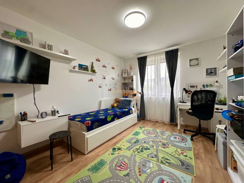 - PREDAJ - Moderný rodinný dom s extrémne nízkymi nákladmi! - Detská izba v rodinnom dome s posteľou, písacím stolom a dekoratívnym kobercom na podlahe.