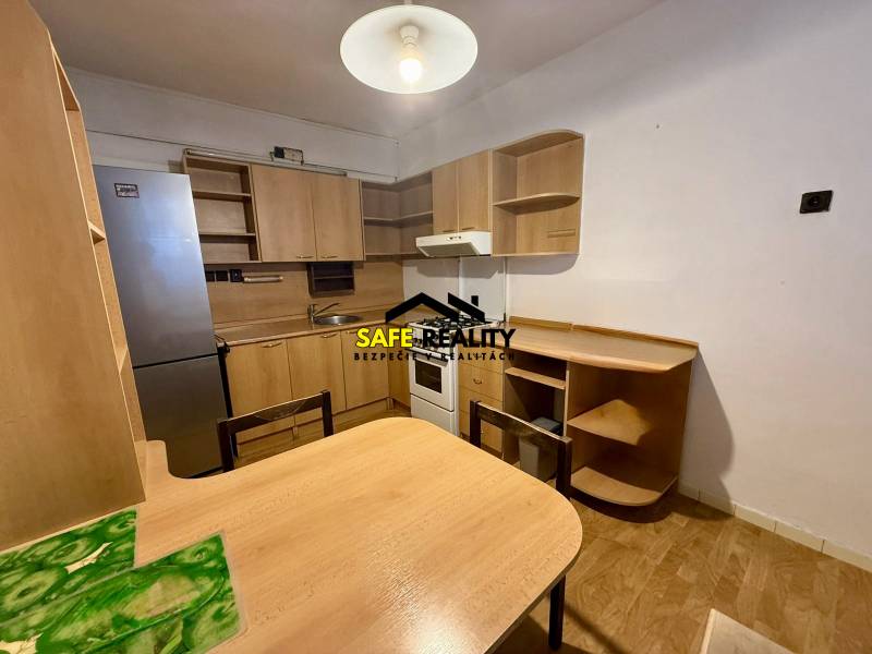 Jednoizbový byt s lodžiou, Žilina - Centrum - Kuchyňa v 1-izbovom byte vybavená drevenou nábytkom a chladničkou.