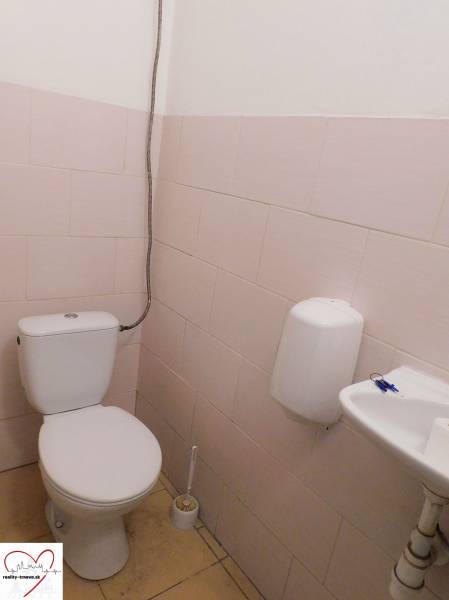 Prenájom skladu a haly, Trnava - Toaleta so záchodom, umývadlom a dávkovačom mydla v priemyselnej budove.