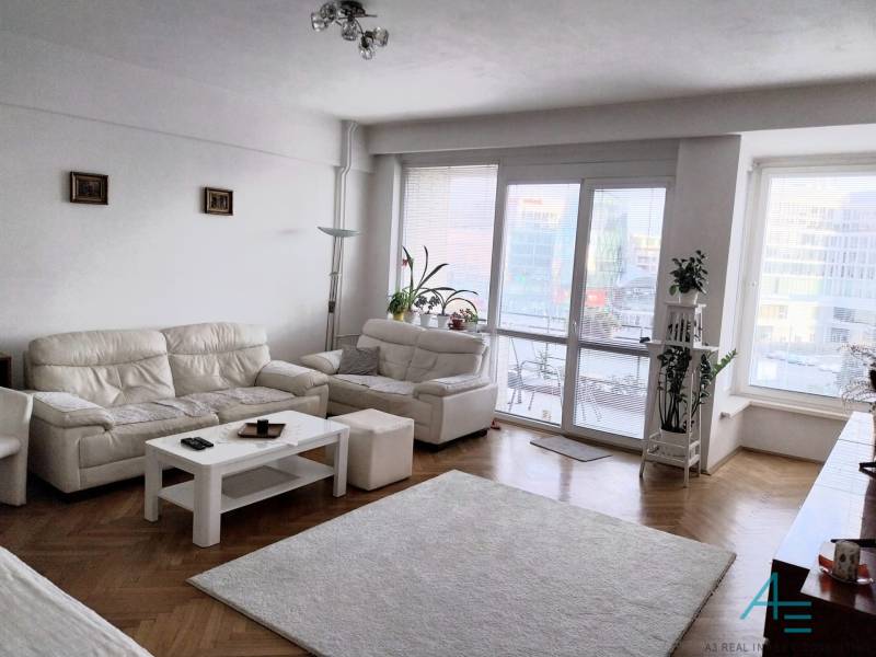 Štýlový  4 izbový  - terasa- lodžia , výťah v centre BA. - Svetlá obývačka s bielymi pohovkami v 4-izbovom byte, presklené dvere na terasu.