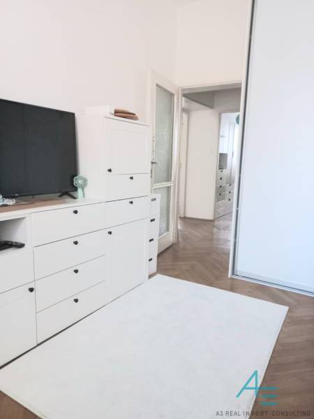 Štýlový  4 izbový  - terasa- lodžia , výťah v centre BA. - Biela obývačka v 4-izbovom byte s TV, skrinkami a drevenou podlahou.