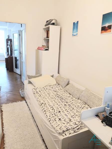 Štýlový  4 izbový  - terasa- lodžia , výťah v centre BA. - Izba v 4-izbovom byte s posteľou, poličkou a vstupom na balkón.