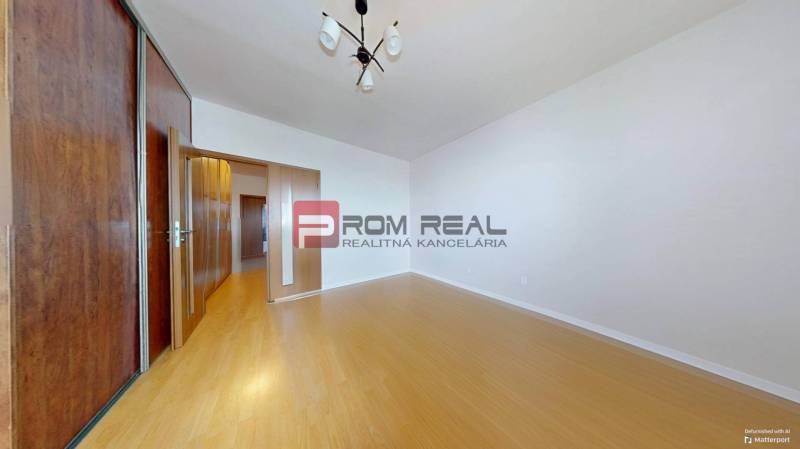 Predaj 3i, 74m2 bytu s výhľadom na Draždiak, Bratislava - Izba s drevenou podlahou, vstavanou skriňou a osvetlením v 3-izbovom byte.