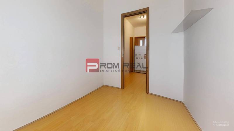Predaj 3i, 74m2 bytu s výhľadom na Draždiak, Bratislava - Izba s drevenou podlahou a bielymi stenami v 3-izbovom byte.