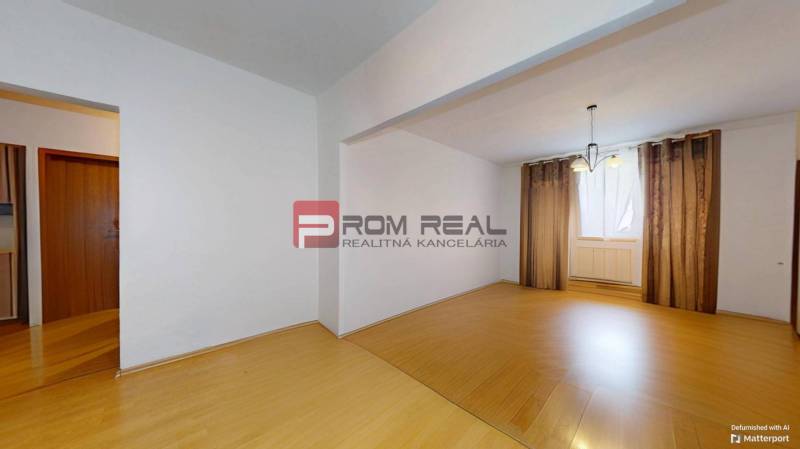 Predaj 3i, 74m2 bytu s výhľadom na Draždiak, Bratislava - Interiér 3-izbového bytu s laminátovou podlahou a závesmi na okne.