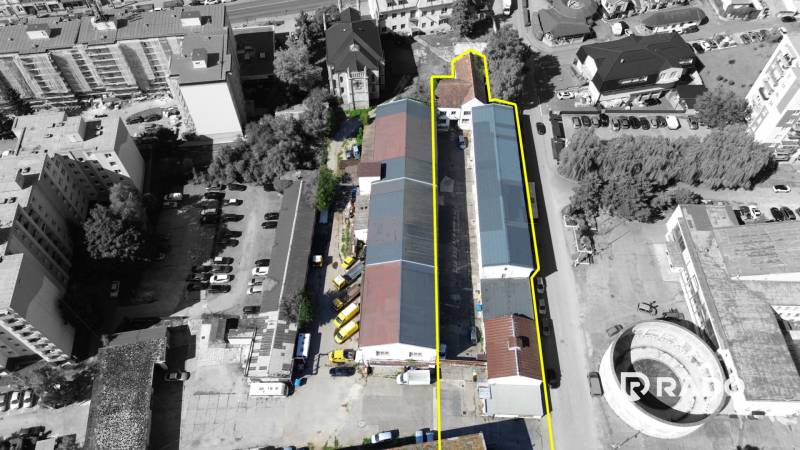 Budova vhodná na developérsky projekt | Vrbové - Letecký pohľad na budovu na Ulici SNP vo Vrbovom, obklopenú parkoviskom.