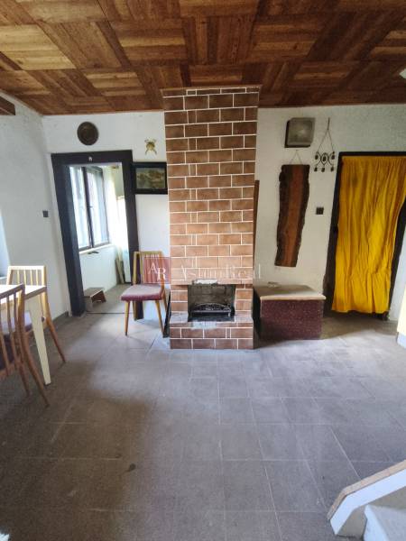 CHATA KORDÍKY - 2 poschodia, 3 izby+kuchynka, kúpelňa - 420 m2 pozemok - Interiér chaty s krbom, oknom a podlahou s dreveným dekorom.
