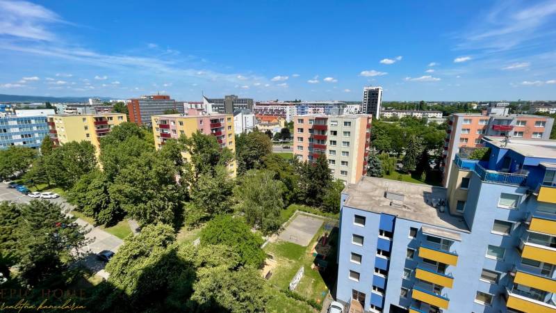 TOP LOKALITA: Zrekonštruovaný 1 izbový byt s loggiou, Ružinov - Výhľad na farebné bytovky a zeleň na Rezedovej ulici v Bratislave - Ružinove.