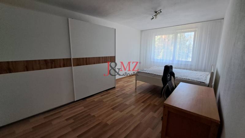 2 izbový byt 65 m2, kompletná rekonštrukcia, Tlmače-Lipník (SM-836) - Svetlá izba v 2-izbovom byte so skriňou, posteľou a písacím stolom.