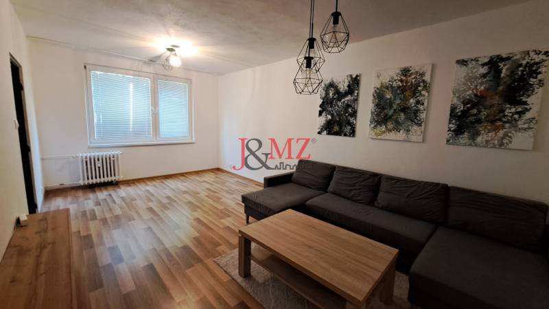2 izbový byt 65 m2, kompletná rekonštrukcia, Tlmače-Lipník (SM-836) - Obývacia izba v 2-izbovom byte s pohovkou, stolíkom a umeleckými obrazmi.