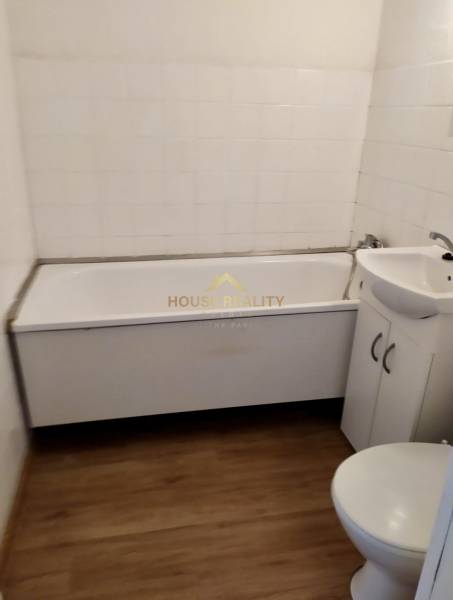 Prenájom pekný 1 izbový byt, Bratislava II. Vrakuňa, Bieloruská ulica - Kúpeľňa v 1-izbovom byte s vaňou, umývadlom a toaletou, dlažba dreveného vzhľadu.