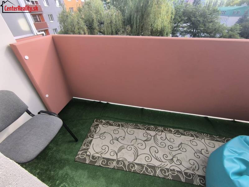 ‼️2 IZBOVÝ BYT NA PRENÁJOM, PARTIZÁNSKE -CENTRUM (KOMPLET ZARIADENÝ)‼️ - Balkón 2-izbového bytu so stoličkami a kobercom na Družstevnej ulici v Partizánskom.
