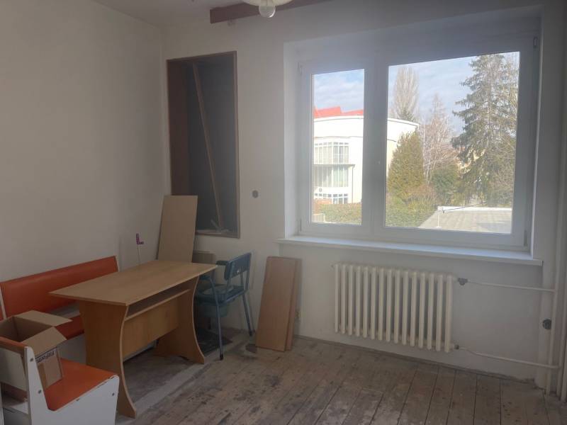 VÝNIMOČNÁ INVESTIČNÁ PRÍLEŽITOSŤ V CENTRE PIEŠŤAN - Interiér rodinného domu s oknom, stolom a oranžovou lavicou.