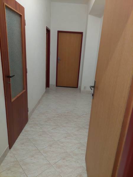 VÝNIMOČNÁ INVESTIČNÁ PRÍLEŽITOSŤ V CENTRE PIEŠŤAN - Chodba v rodinnom dome s dlažbou a drevenými dverami.
