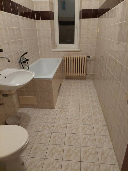 VÝNIMOČNÁ INVESTIČNÁ PRÍLEŽITOSŤ V CENTRE PIEŠŤAN - Kúpeľňa v rodinnom dome s vaňou, umývadlom, WC a radiátorom na stene.