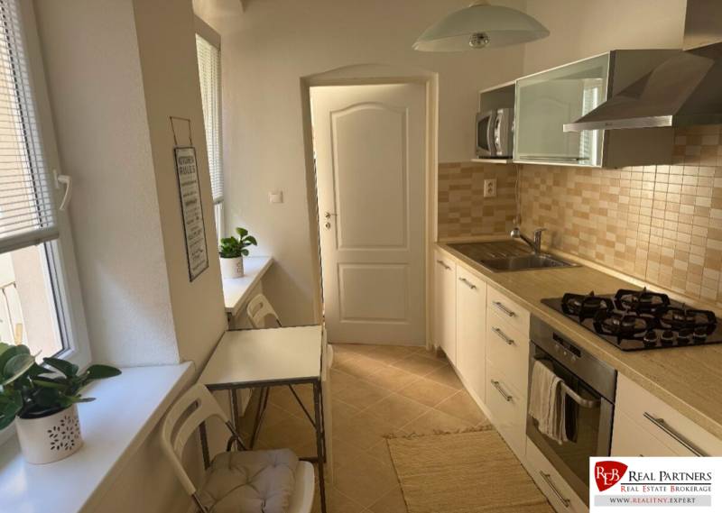 Prenájom 2-izb bytu na Ventúrskej ulici, Bratislava- centrum - Kuchyňa v 2-izbovom byte so svetlým nábytkom, spotrebičmi a jedálenským stolom.