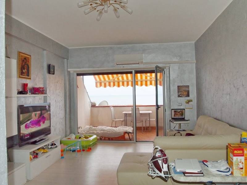 Predaj bytu 3-izbového (3+kk) s rozlohou 65 m² a terasou 10 m², Scalea - Obývačka v 3-izbovom byte s terasou, televíziou a pohodlnými sedačkami.